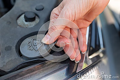 Daily diagnostics of the car by the driver. Refilling car washer fluid Stock Photo