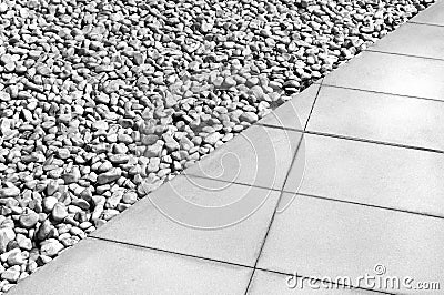 Diagonal dividing line between gray tiles and white gravel Stock Photo