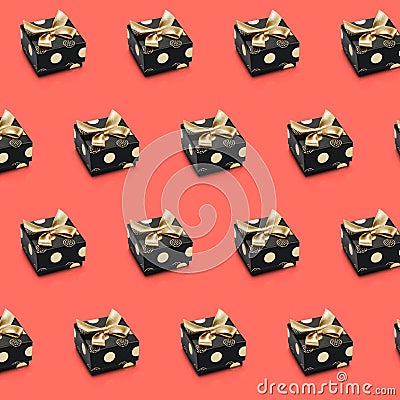 Diagonal lines of black wrapped present boxes on living coral color background. Stock Photo