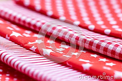 Diagonal textural background of five types of red and white cotton fabric with different prints: checkered, striped, circle, star Stock Photo