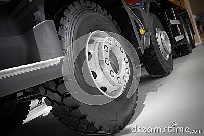 Diagonal view on tipper truck wheels and tires with blured background. Truck wheel rim. Truck chassis exhibit on car Exhibition. C Editorial Stock Photo