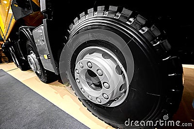 Diagonal view on tipper truck wheels and tires with blured background. Truck wheel rim. Truck chassis exhibit on car Exhibition. C Editorial Stock Photo