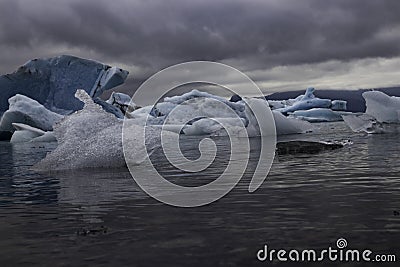 Diamond-like Ice Floats Through Lagoon On Dark Day Stock Photo