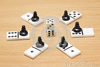 Dice around which dominoes and black chess pawns Stock Photo