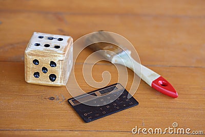 A dice with a calculator and a carpenter's brush symbolize work, passion and sober calculation, background Stock Photo