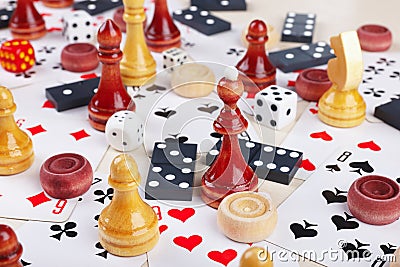 Dice, chess pieces, playing cards, wooden checkers and dominoes for board games on light table close up Stock Photo