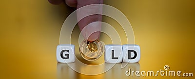 Dice form the word gold in front of a golden background. Stock Photo