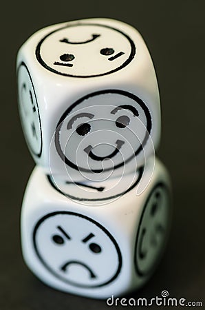 Dice with opposite sad and happy emoticon sides Stock Photo