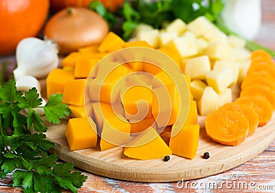 Diced vegetables for cooking pumpkin soup on a wooden background. Healthy food concept. Close-up Stock Photo