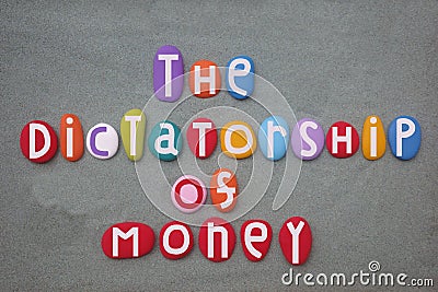 The dictatorship of money, social slogan composed with multi colored stone letters over green sand Stock Photo