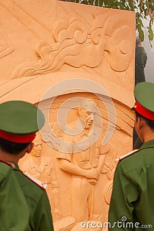 Portrait of young vietnamese soldier in green uniform looking at statue of the French General De Castries at the bunker. Dien Bien Editorial Stock Photo