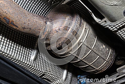 A diesel particulate filter in the exhaust system in a car on a lift in a car workshop, seen from below. Stock Photo