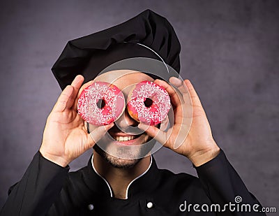 Close up portrait of happy cute chef cooker with sweet donuts Stock Photo