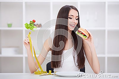 Diet. Dieting concept. Girl choosing healthy vs junk food. Stock Photo