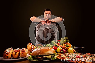 Diet fat man makes choice between healthy and unhealthy food. Stock Photo