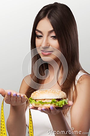 Diet. Harmful and useful food. A young girl makes a choice either for a diet or for a meal. Sport. The concept of health and beau Stock Photo