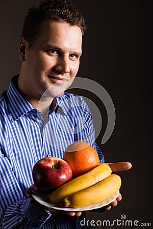 Diet nutrition. Happy young man holding fruits. Stock Photo