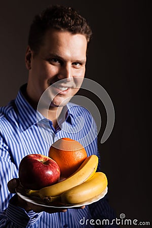 Diet nutrition. Happy young man holding fruits. Stock Photo