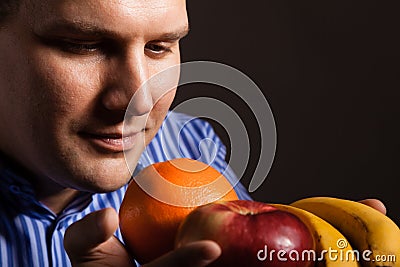 Diet nutrition. Happy young man smelling fruits. Stock Photo