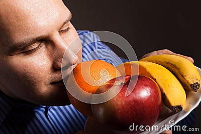 Diet nutrition. Happy young man smelling fruits. Stock Photo