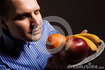 Diet nutrition. Happy young man smelling fruits. Stock Photo