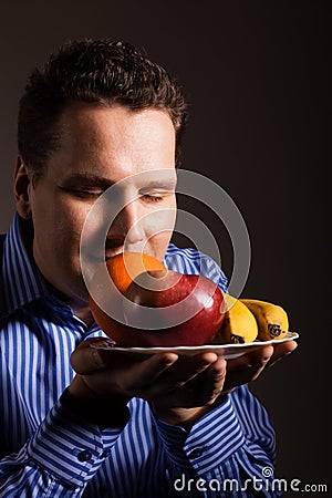 Diet nutrition. Happy young man smelling fruits. Stock Photo