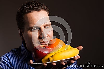 Diet nutrition. Happy young man smelling fruits. Stock Photo