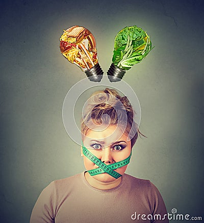 Diet restriction stress. Frustrated woman with measuring tape around her mouth Stock Photo