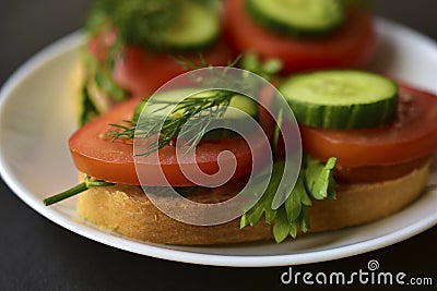 Diet sandwiches with greens, cucumber and tomato on a white plate Stock Photo