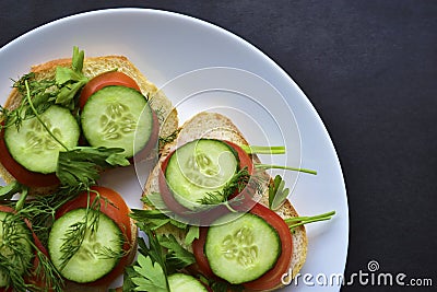 Diet sandwiches with greens, cucumber and tomato on a white plate Stock Photo