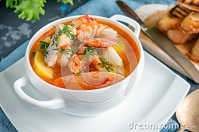 Diet soup of seafood and fish of different varieties in a white soup plate. Close up Stock Photo
