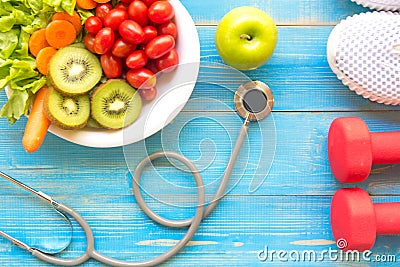 Diet and weight loss for healthy care with medical stethoscope, fitness equipment,measuring tap,fresh water and green apple on woo Stock Photo