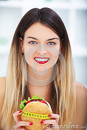 Diet. Young beautiful woman eating burger, It`s junk and unhealt Stock Photo