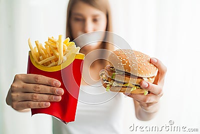 Diet. Young woman with duct tape over her mouth, preventing her to eat junk food. Healthy eating concept Stock Photo