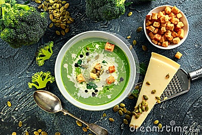 Dietary Broccoli smooth cream soup with sprinkle of sunflower seeds, parsley leaves and croutons on stone table. Stock Photo