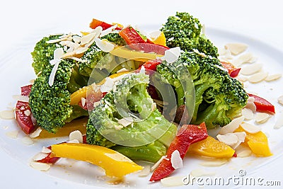 Dietary broccoli with vegetables and peanuts. On a white plate Stock Photo