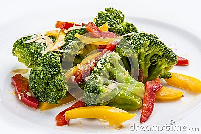 Dietary broccoli with vegetables and peanuts. On a white plate Stock Photo