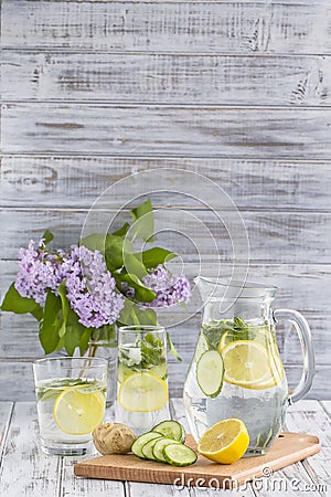Dietary detox drink with lemon juice, ginger, cucumber and mint leaves in clear water with ice. Stock Photo