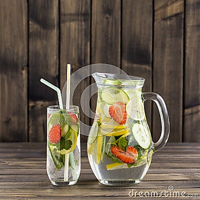 Dietary detox drink with lemon juice, red strawberry, cucumber and mint leaves in clear water with ice. Stock Photo