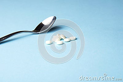 Dietary supplements. Vitamin tablets in an iron spoon on a blue background. Stock Photo