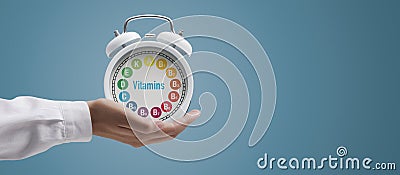 Dietician holding a clock with vitamins Stock Photo