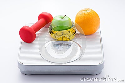 Dieting weight-loss slim down concept. Closeup measuring tape on white weight scale Stock Photo