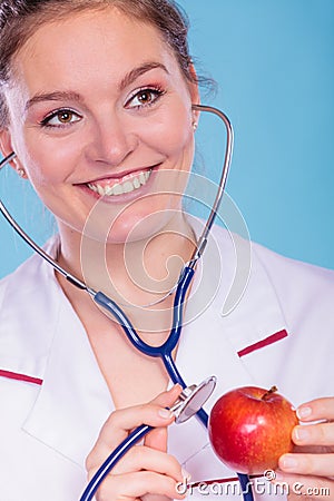 Dietitian examine apple fruit with stethoscope. Stock Photo