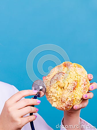 Dietitian examine sweet bun with stethoscope Stock Photo