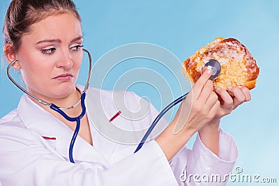 Dietitian examine sweet roll bun with stethoscope. Stock Photo