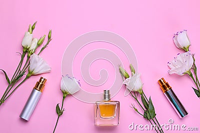 Bottles of perfume and beautiful flowers eustoma on a bright pink background. Women`s accessories. top view Stock Photo