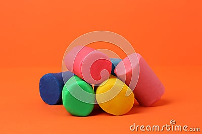 Different bright play dough on orange background Stock Photo