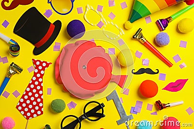 Different clown`s accessories on yellow background, flat lay Stock Photo