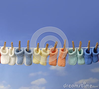 Different colored baby booties on a clothes line Stock Photo