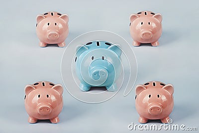 Different colored piggy bank standing out of the crowd. The uniqueness and leadership concept, individuality and difference. Stock Photo